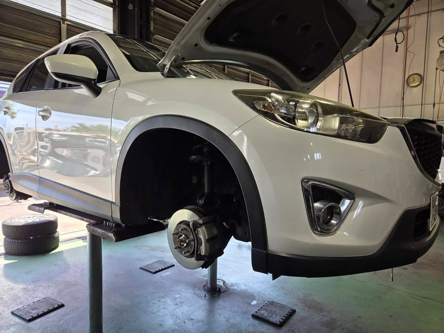 車検の点検でタイヤを外してリフトアップしているMAZDA CX-5（白）
