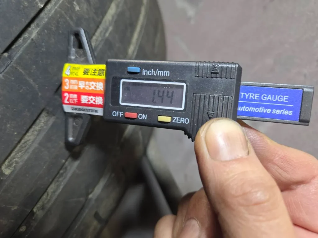 タイヤの溝の深さを計測機で確認している様子