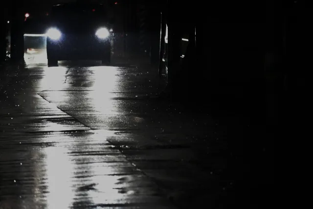 夜の車道、前方からヘッドライトの光